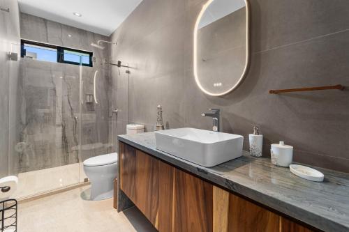 クルス・デ・ウアナカストレにあるTamaran Family Villas with Beach Club - B Nayarの洗面台、トイレ、鏡のあるバスルーム