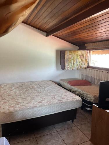a bedroom with two beds and a window in it at Casa Dos Carandas in Itanhaém