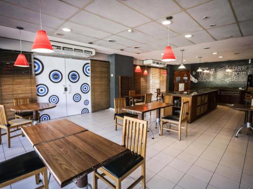 a dining room with wooden tables and chairs at Ibis Teresina in Teresina