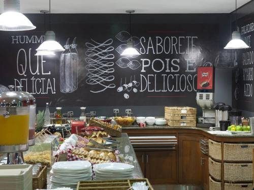 a kitchen with a counter with plates of food at Ibis Teresina in Teresina