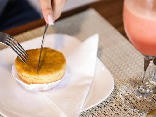 a person cutting into a dessert on a plate with a fork at Ibis Teresina in Teresina
