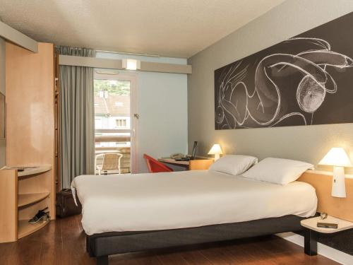 a hotel room with a large bed and a window at ibis La Bresse Gérardmer in La Bresse