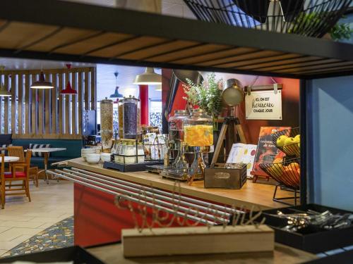 a restaurant with a counter with food on it at ibis La Bresse Gérardmer in La Bresse