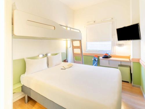 a bedroom with a white bed and a bunk bed at Ibis Budget Madrid Calle Alcalá in Madrid