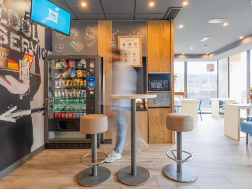 a person is standing in front of a refrigerator at Ibis Budget Madrid Calle Alcalá in Madrid