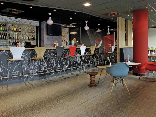 a bar with chairs and a counter in a room at ibis Amsterdam City West in Amsterdam
