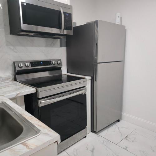 a kitchen with a stove and a microwave and a refrigerator at Araly's house in Tampa