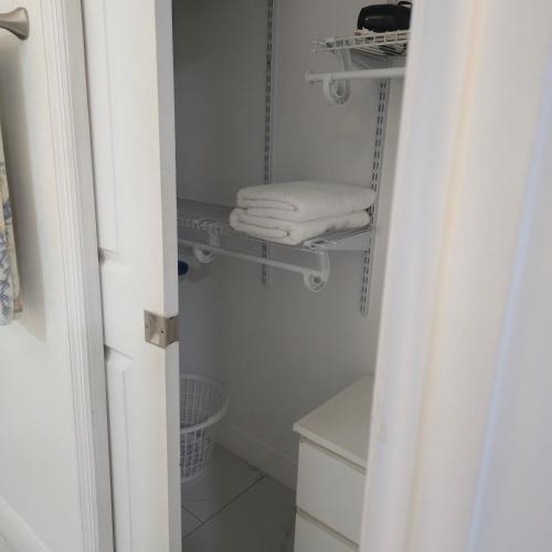 a bathroom with white towels on a shelf at Araly's house in Tampa