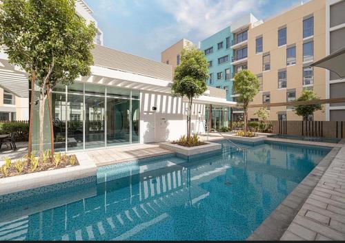 a swimming pool in front of a building at The Opal residence IBR in Sharjah