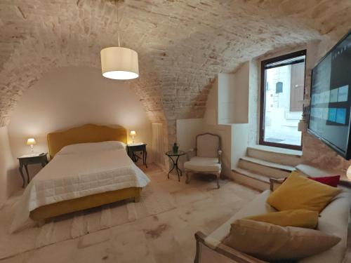ein Schlafzimmer mit einem Bett, einer Couch und einem Fernseher in der Unterkunft Old Town Suite Martina in Martina Franca