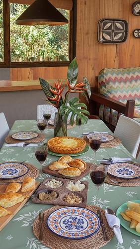 a table with plates of food and glasses of wine at ANAVÁ casa en la selva in El Soberbio