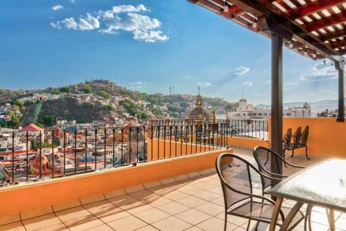 a balcony with chairs and a view of a city at Casa Tres Lunas Centro in Guanajuato