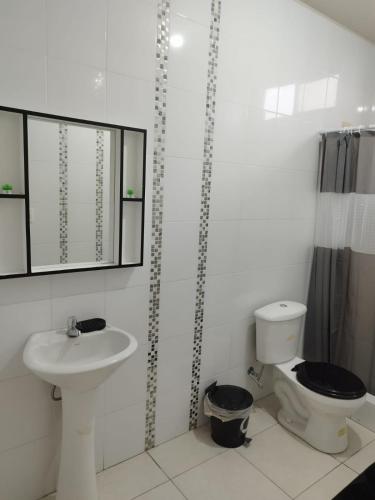 a white bathroom with a sink and a toilet at Casa Familiar a 5 minutos de la playa in Salinas