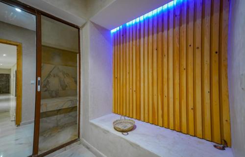 a bathroom with a wooden wall and a mirror at Villa de Luxe à Marrakech avec Piscine Chauffée Privée in Aghmat