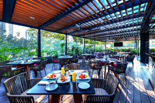 a restaurant with tables and chairs with food on them at Krystal Grand Suites Insurgentes in Mexico City