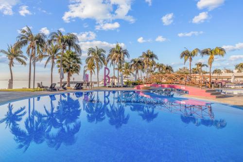 a pool with palm trees and a roller coaster at Tamaran Family Villas with Beach Club - B Nayar in Cruz de Huanacaxtle