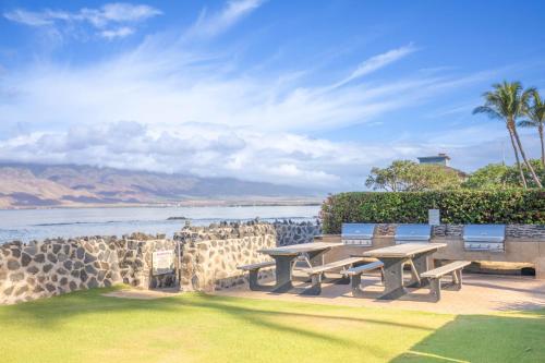a group of benches sitting next to the water at Menehune Shores 601 condo in Kihei
