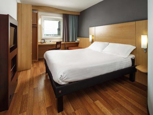 a hotel room with a large bed and a desk at ibis Aberdeen Centre – Quayside in Aberdeen