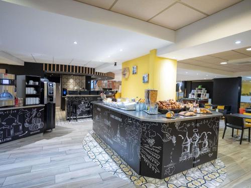 a restaurant with a counter with food on it at Ibis Styles Cognac in Châteaubernard