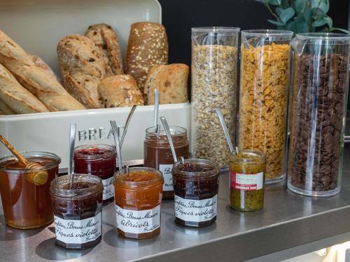 a shelf with many jars of food and bread at Ibis Styles Cognac in Châteaubernard