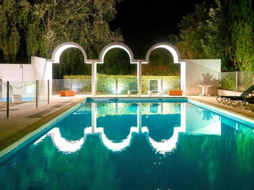 a swimming pool in a backyard at night at Ibis Styles Cognac in Châteaubernard