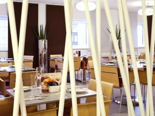 a restaurant with tables and chairs and a table with food at ibis Aberdeen Centre – Quayside in Aberdeen