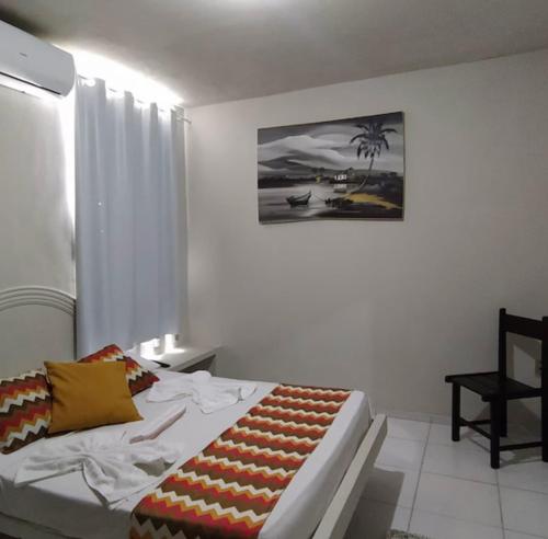 a bedroom with a bed and a picture on the wall at Hotel Pousada Sol in Natal