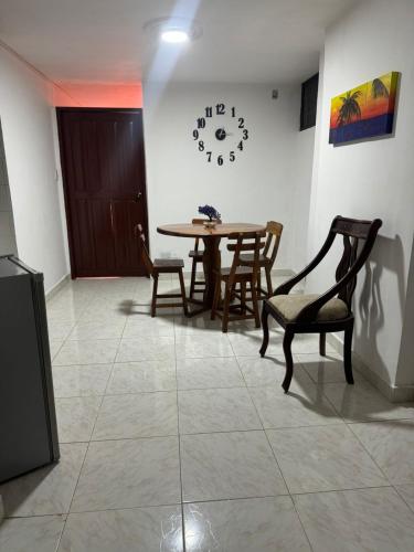 a dining room with a table and chairs and a clock at Estrella de Mar in Rodadero