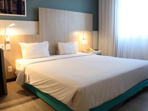 a large white bed in a hotel room at Mercure Salvador Rio Vermelho in Salvador