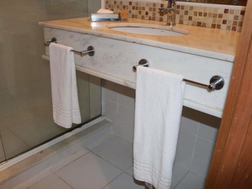 a bathroom with two towels hanging on a sink at Mercure Salvador Rio Vermelho in Salvador
