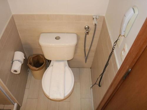 a small bathroom with a toilet and a phone at Mercure Salvador Rio Vermelho in Salvador