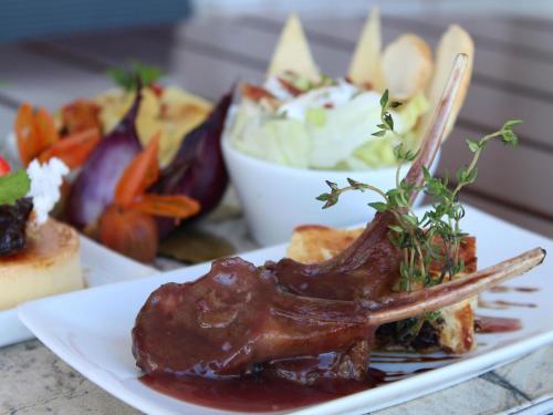 a plate of food with meat and vegetables on a table at Mercure Salvador Rio Vermelho in Salvador