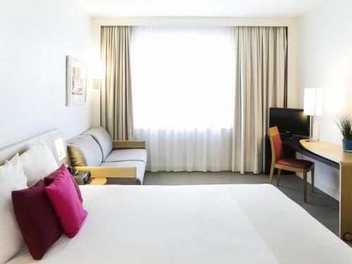 a hotel room with a bed and a desk at Novotel Vilnius Centre in Vilnius