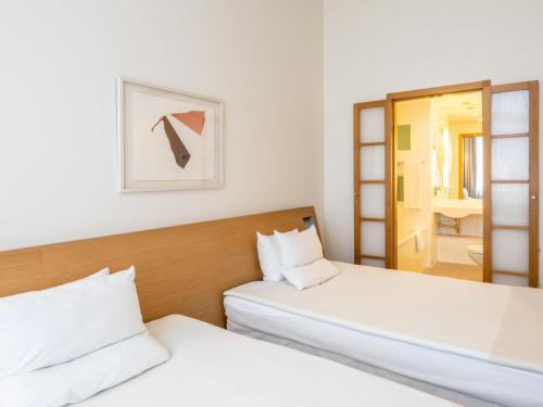 two beds in a room with a mirror at Novotel Vilnius Centre in Vilnius