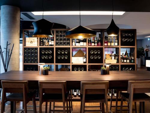 a dining room with a large wooden table and chairs at Novotel Vilnius Centre in Vilnius