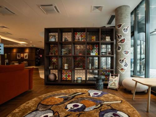 a room with a large glass cabinet filled with vases at Novotel Vilnius Centre in Vilnius