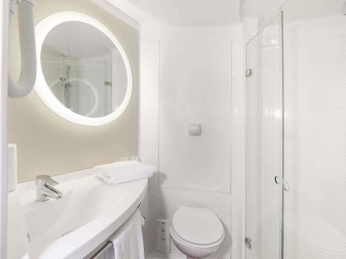 a white bathroom with a toilet and a mirror at ibis Styles Toulouse Lavaur in Lavaur