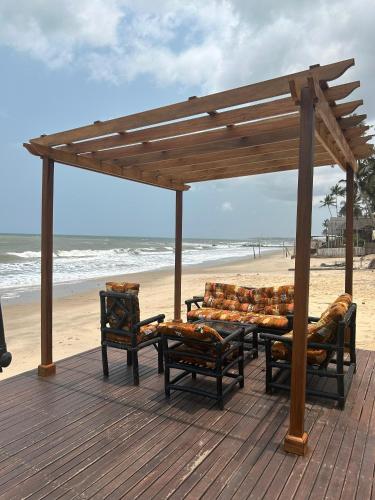un ponte di legno con panchine sulla spiaggia di Shapes Beach House a Kokrobite