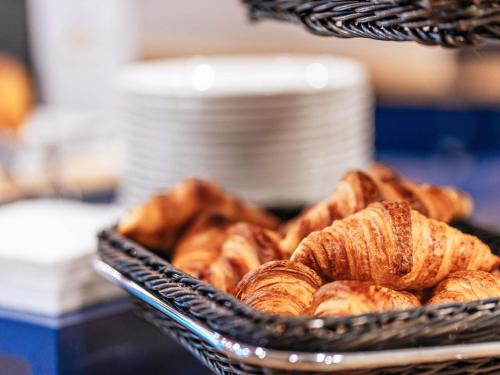 a basket of croissants sitting on a table at ibis Styles Toulouse Lavaur in Lavaur
