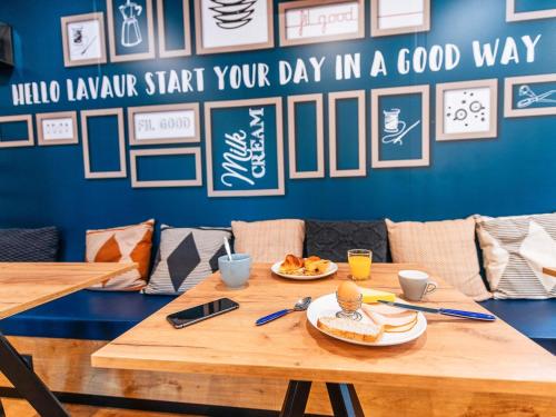 a wooden table with two plates of food on it at ibis Styles Toulouse Lavaur in Lavaur