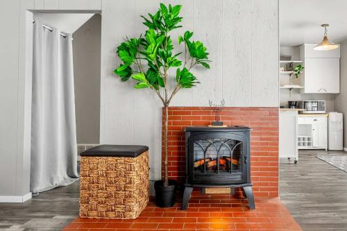 une cheminée en briques dans un salon avec un arbre dans l'établissement Lakefront Cabin - Cozy Retreat - 5Beds - TV - Wifi, à Barrhead