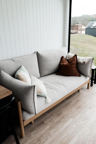 a couch sitting on a porch with pillows on it at Swell At Cape Bridgewater in Cape Bridgewater