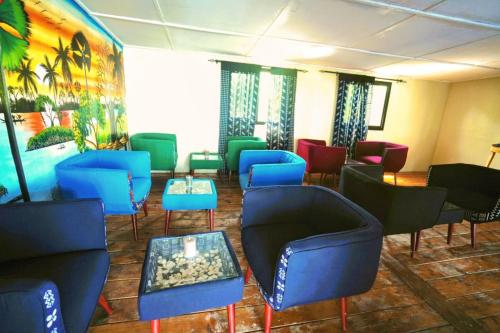 a waiting room with blue and green chairs and tables at Maison flottante SWEET MALBALY - chambre double - vue imprenable sur mer- iles du saloum in Fatick