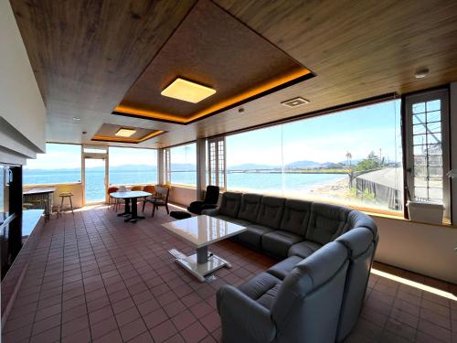a living room with a couch and a large window at 貸別荘 波音と朝日 namine to ASAHI in Miyazu