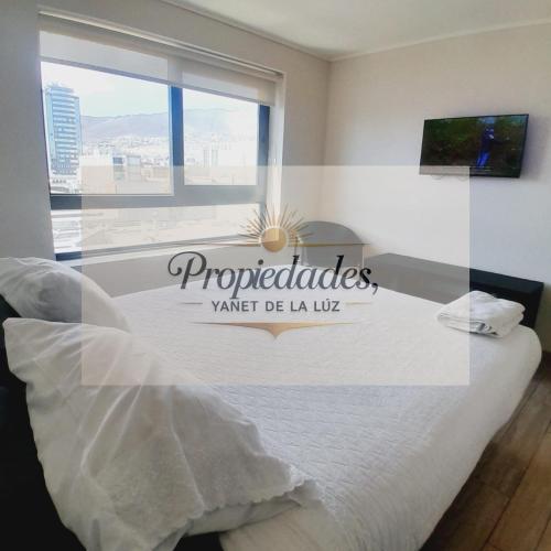 a bedroom with a bed with a sign on the window at Departamento Central Vip in Antofagasta
