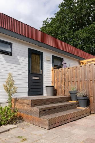 AnlooにあるChalet de Bosrandの木製のデッキと黒いドアのある家