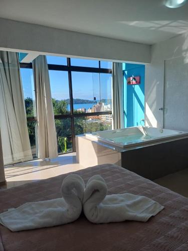 a bed with a heart shaped towel on it in a bedroom at Suíte Atlântica com banheira de hidromassagem in Bombinhas