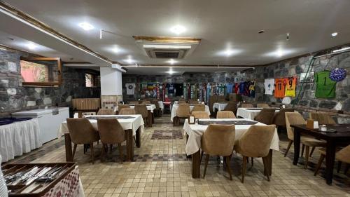 a restaurant with tables and chairs in a room at La Fontaine Otel in Mudanya
