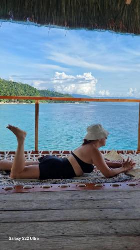 a woman in a bikini laying on the beach at Chue&larry's Beachside Homestay in Libagon