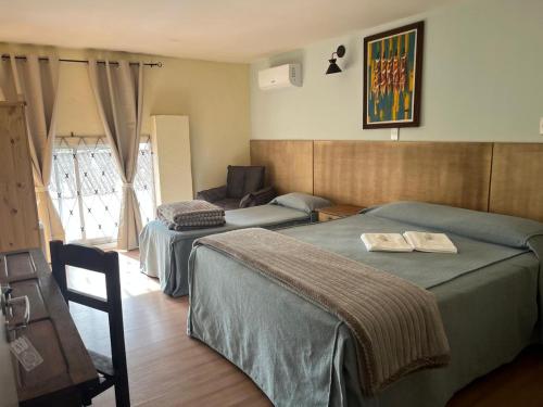 a hotel room with two beds and a couch at Pousada Raio de Sol in Jaguarão